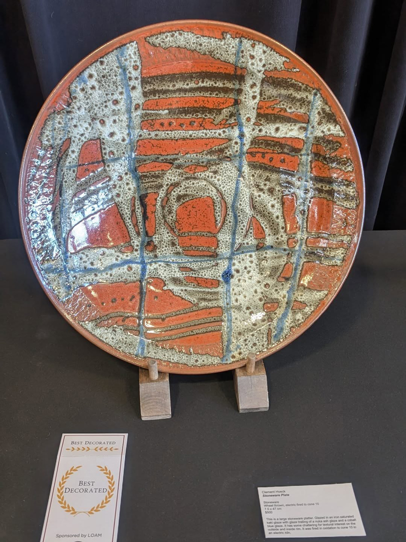 Photo of award-winning-artistic glazed ceramic plate in orange, blue, and off-white