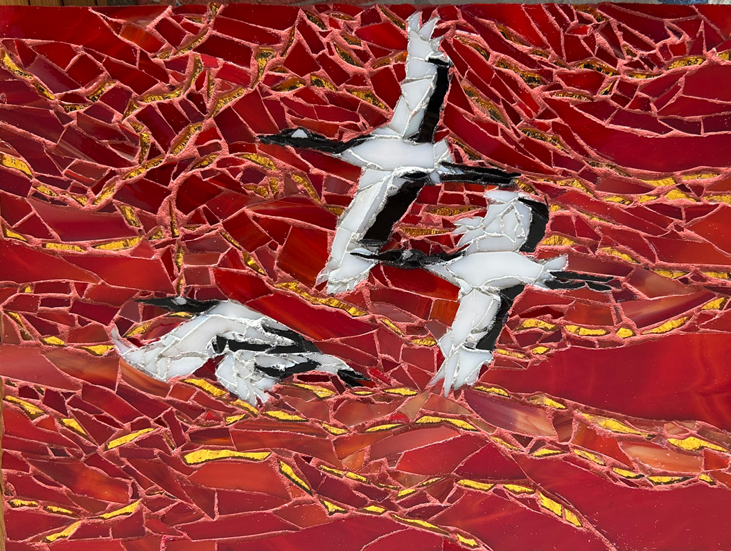 mosaic of canada geese flying across red and gold sky