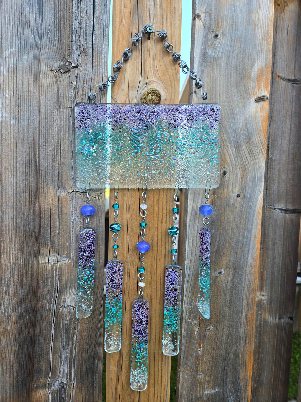 Photo of glass art piece in purple and turquoise