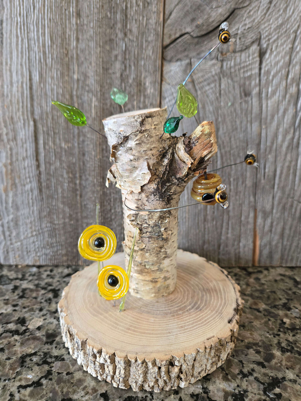 Photo of glass art piece with birch branch and honeybees