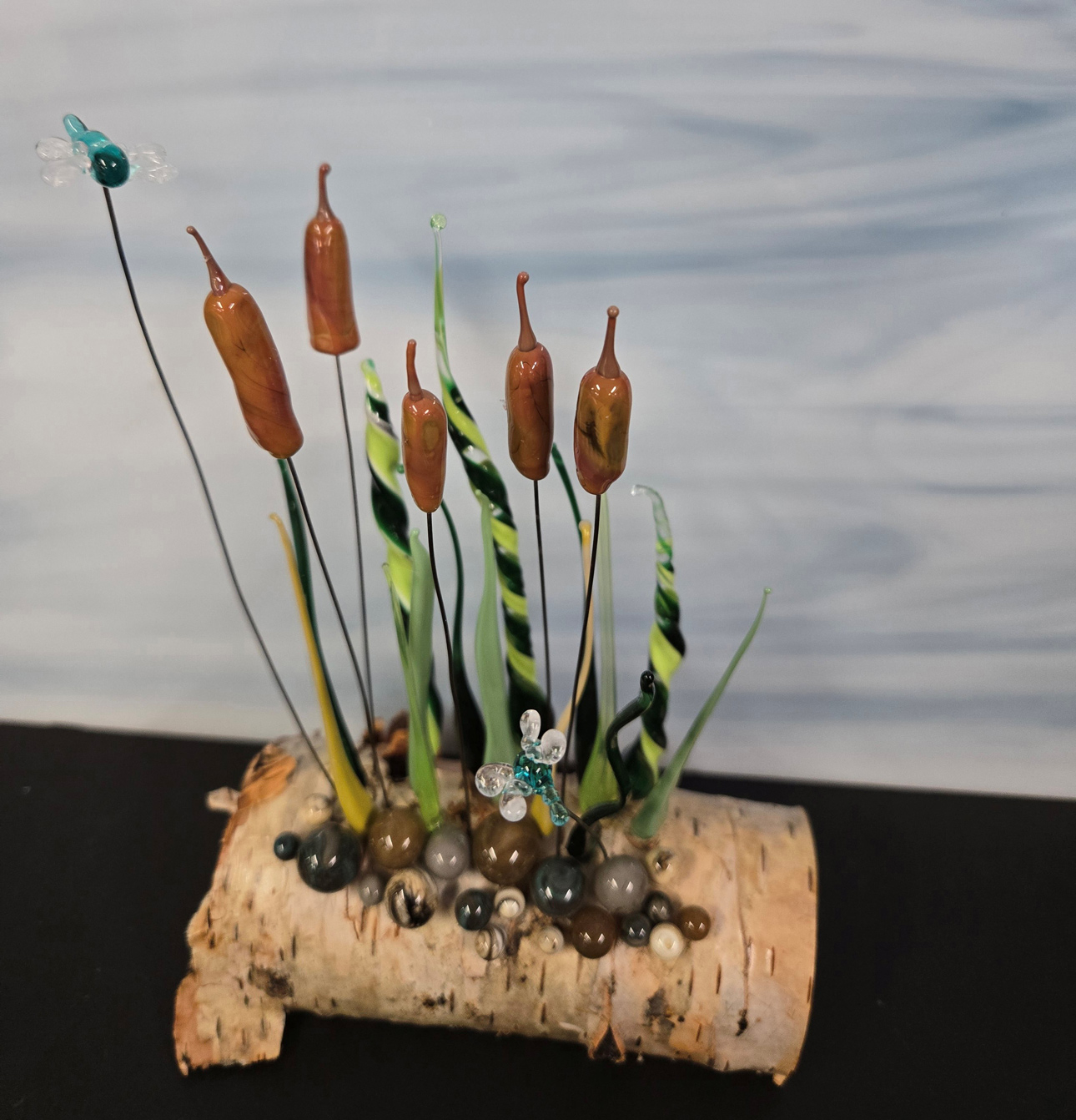 Photo of glass art piece with birch branch, cat tails, and honeybees